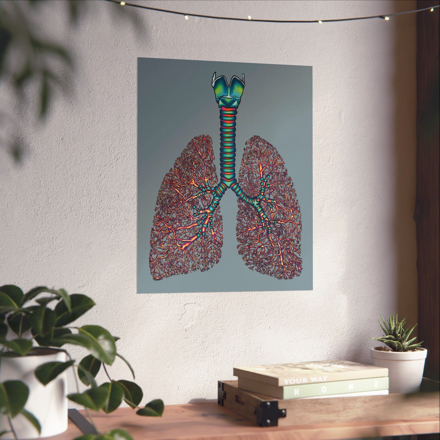 Large poster displayed on a wall in a home setting, featuring an illustration of anatomical lungs with detailed bronchial tree, trachea, and larynx, set against a blue-grey background.