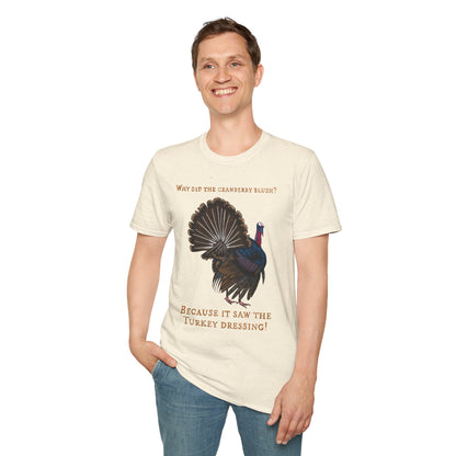 Man wearing a beige Thanksgiving t-shirt featuring a picture of a turkey and the text 'Why did the cranberry blush? Because it saw the turkey dressing!