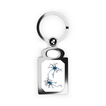Rectangular silver frame keychain featuring a drawing of two blue neurons forming a synapse, set against a white background.
