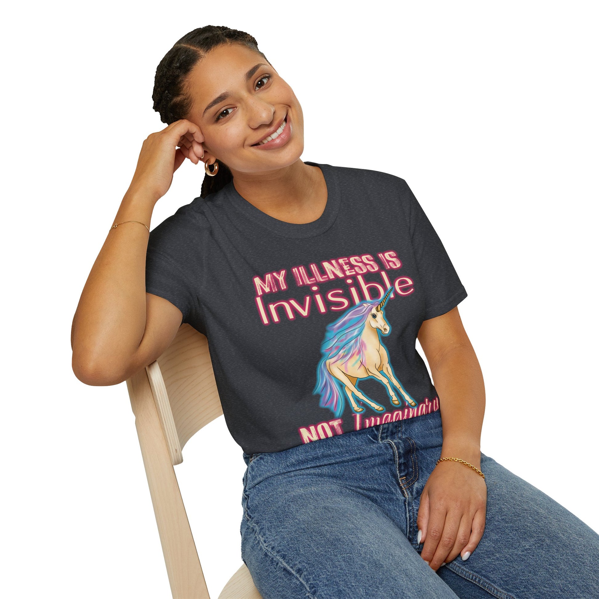 Woman wearing a dark grey shirt featuring a drawing of a unicorn and the phrase 'My illness is invisible not imaginary'.
