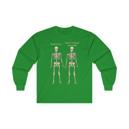 A kelly green long sleeve shirt with two skeletons side by side—one labeled "normal," the other "Ehlers-Danlos Syndrome"—visually showcasing the effects of EDS with a clever, anatomy-inspired twist.