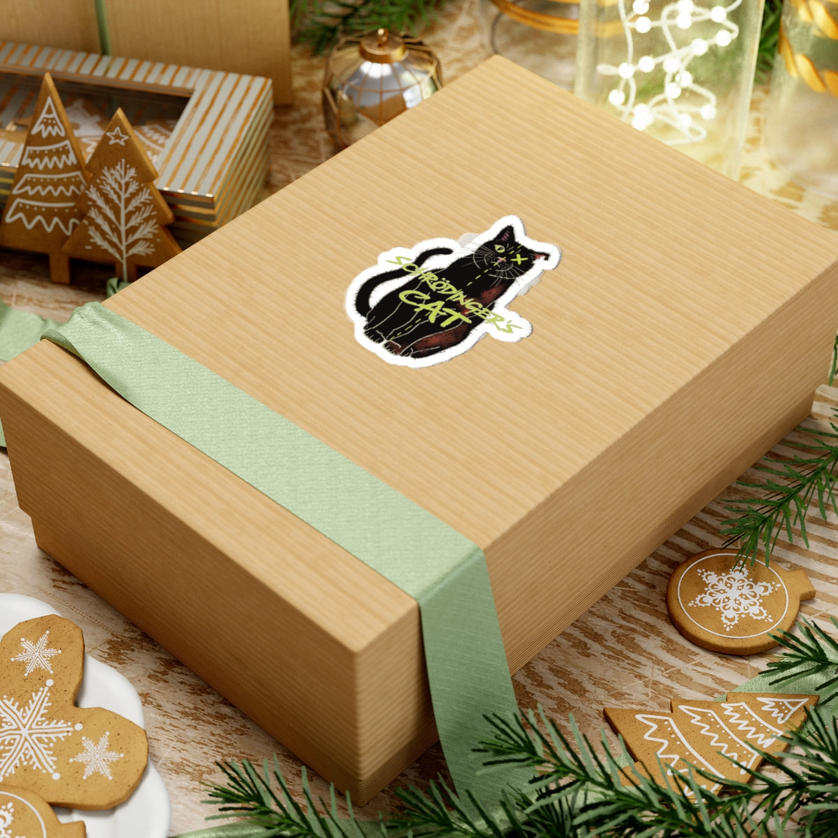 Small sticker adhered to a gift featuring a black cat with one half depicted as alive and the other half as dead, with an X over one eye, representing Schrödinger's cat.