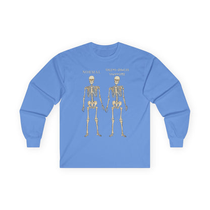 A light blue long sleeve shirt with two skeletons side by side—one labeled "normal," the other "Ehlers-Danlos Syndrome"—visually showcasing the effects of EDS with a clever, anatomy-inspired twist.