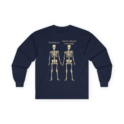A navy long sleeve shirt with two skeletons side by side—one labeled "normal," the other "Ehlers-Danlos Syndrome"—visually showcasing the effects of EDS with a clever, anatomy-inspired twist.