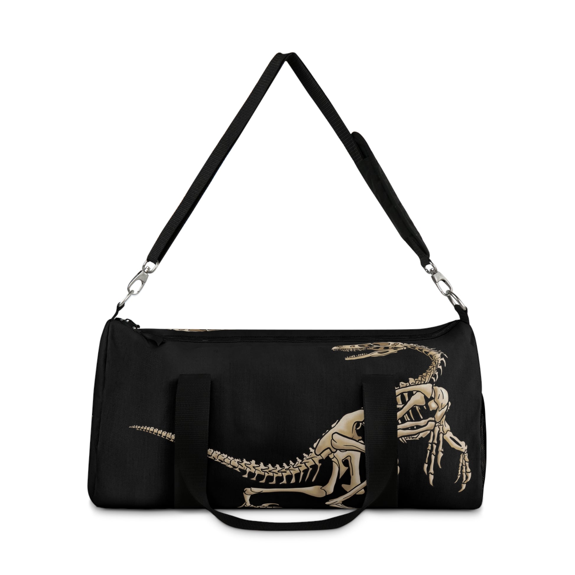 Back view of a black duffel bag the shoulder strap up with bone-beige illustrations of velociraptor skeleton fossils—perfect for carrying your gear while channeling serious prehistoric predator energy.