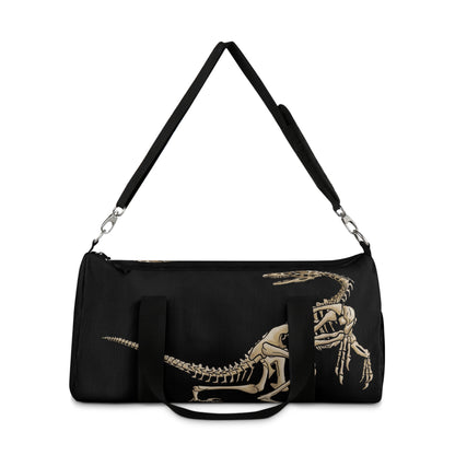 Back view of a black duffel bag the shoulder strap up with bone-beige illustrations of velociraptor skeleton fossils—perfect for carrying your gear while channeling serious prehistoric predator energy.