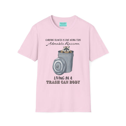 Light pink t-shirt featuring an illustration of a raccoon in a metal trash can, with the phrase 'Chronic illness is like being this adorable raccoon living in a trash can body' printed on it.