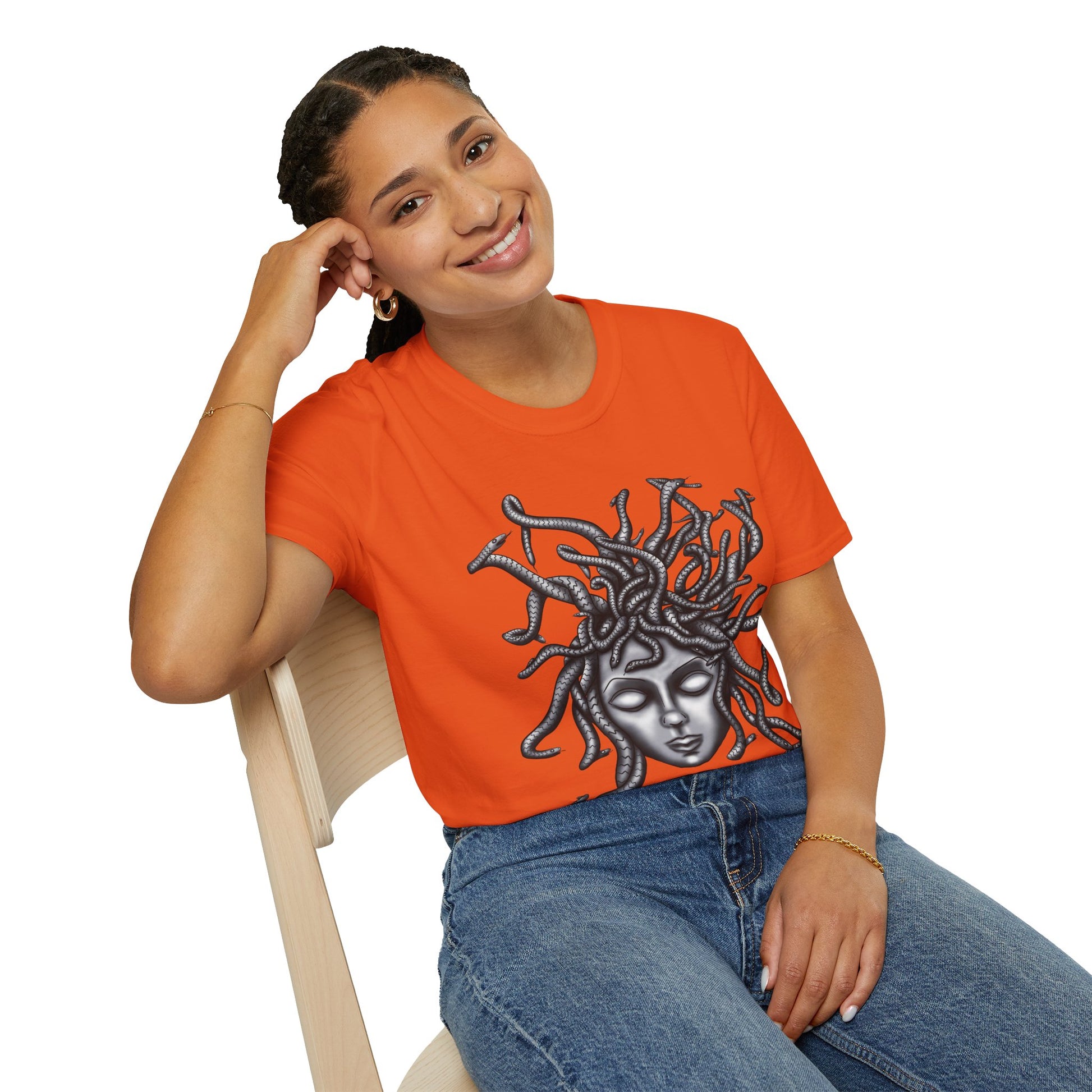 Woman wearing an orange t-shirt featuring a grayscale drawing of Medusa.