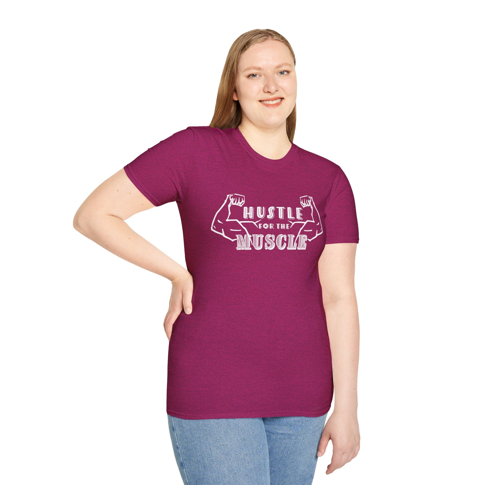 Woman wearing a pink unisex short sleeve t-shirt featuring a pair of flexed, muscle-bound arms and the bold text "Hustle for the Muscle"—because gains don’t come from wishes, they come from reps.