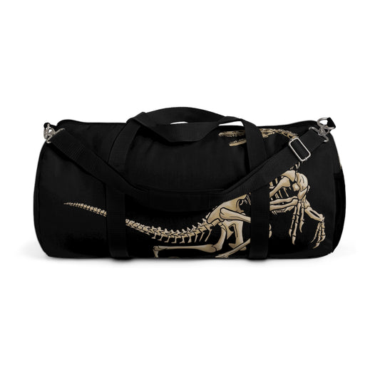 Front view of a black duffel bag with bone-beige illustrations of velociraptor skeleton fossils—perfect for carrying your gear while channeling serious prehistoric predator energy.