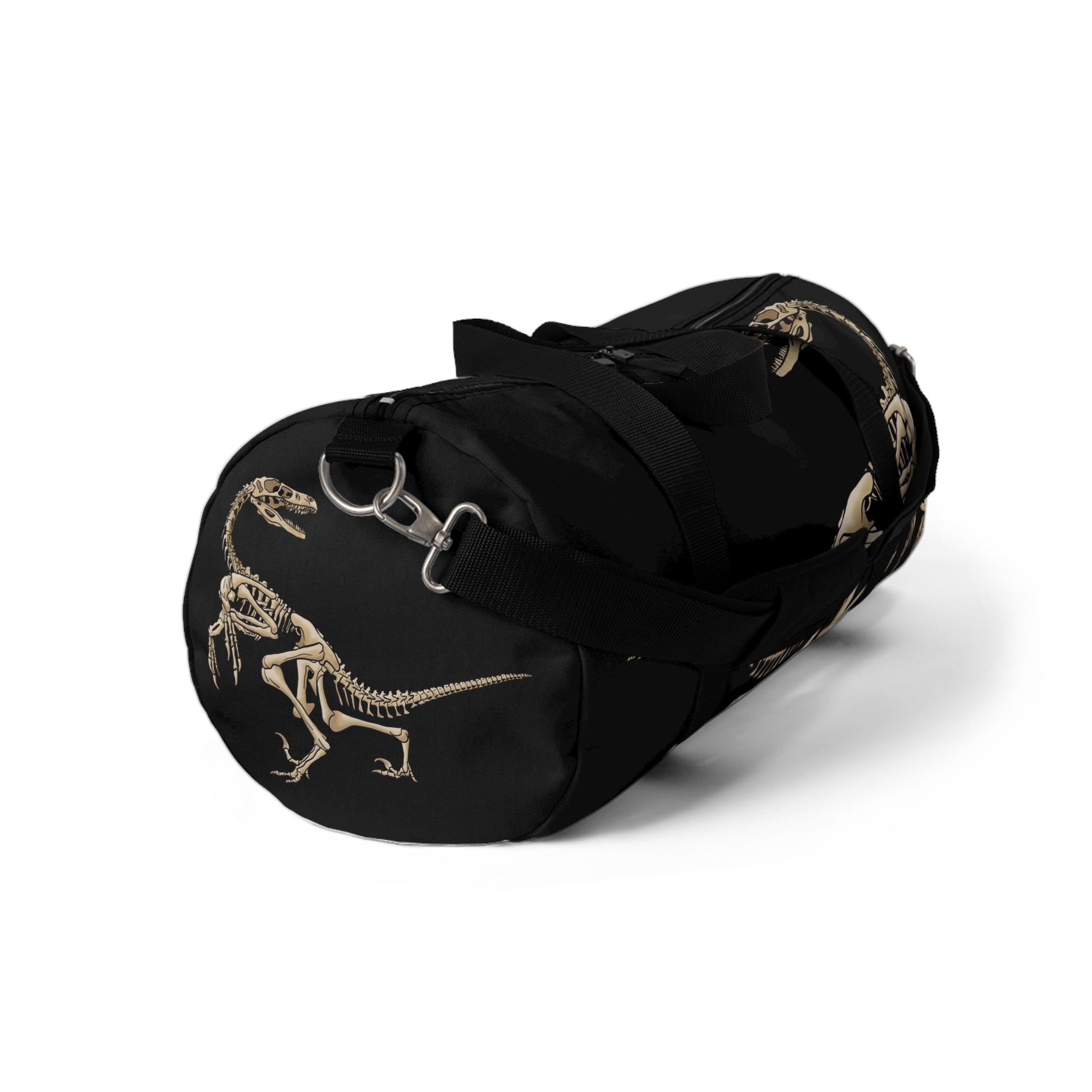 Side view of a black duffel bag with bone-beige illustrations of velociraptor skeleton fossils—perfect for carrying your gear while channeling serious prehistoric predator energy.